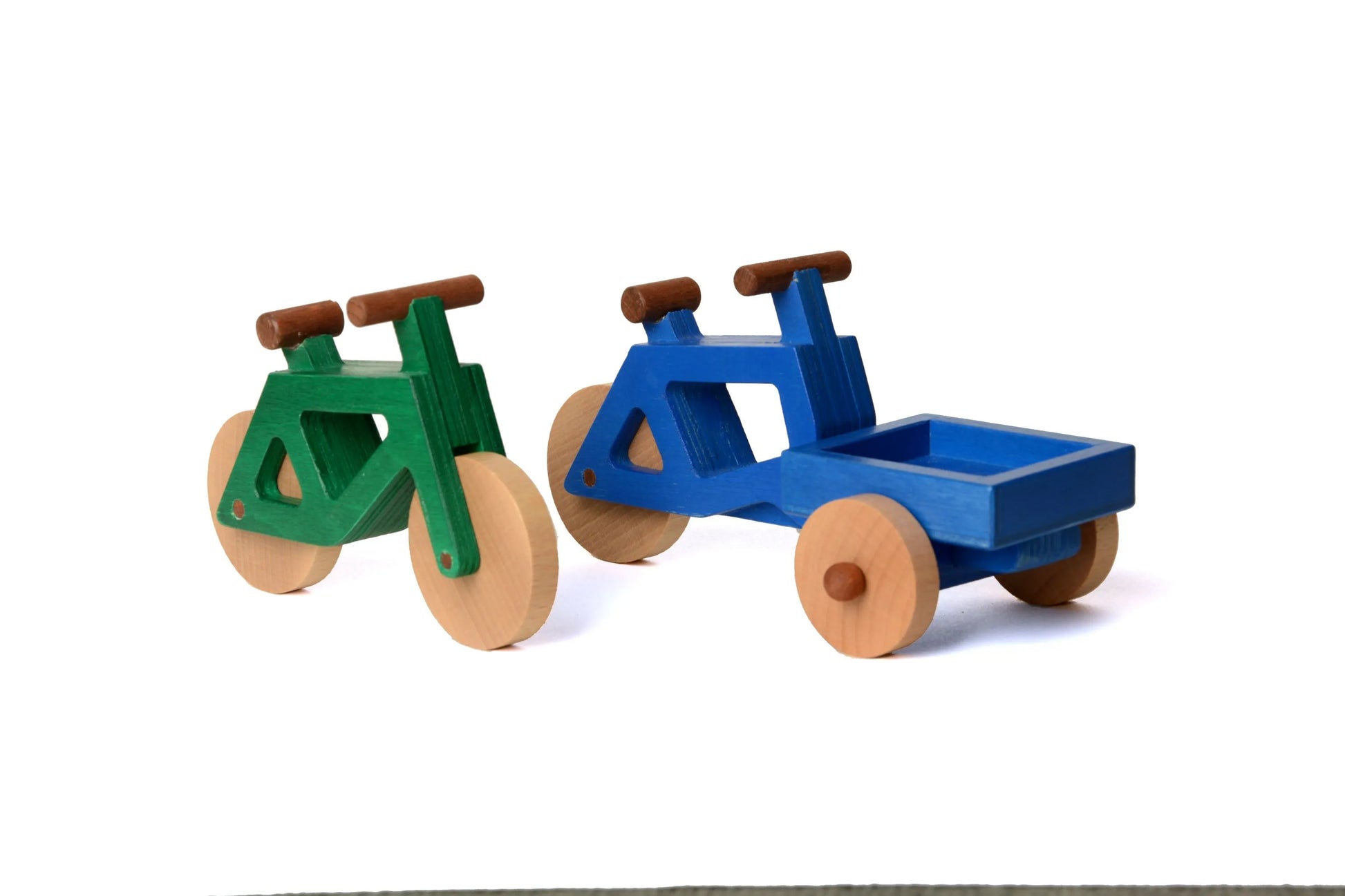 Das Spielzeugfahrrad aus Holz in grün und das Lastenrad von Spielwende in blau