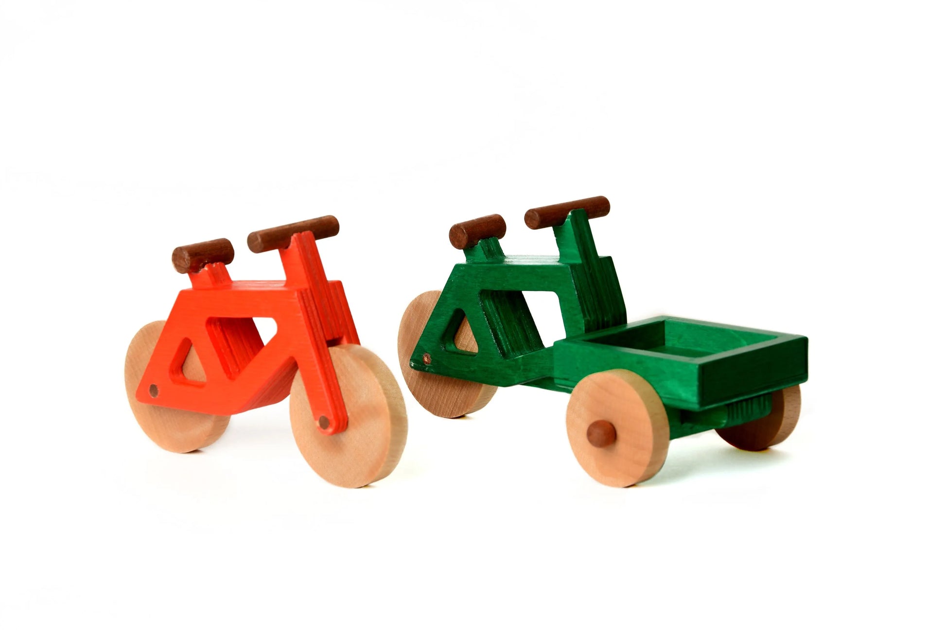 Das Spielzeugfahrrad aus Holz in rot und das Lastenrad von Spielwende in grün