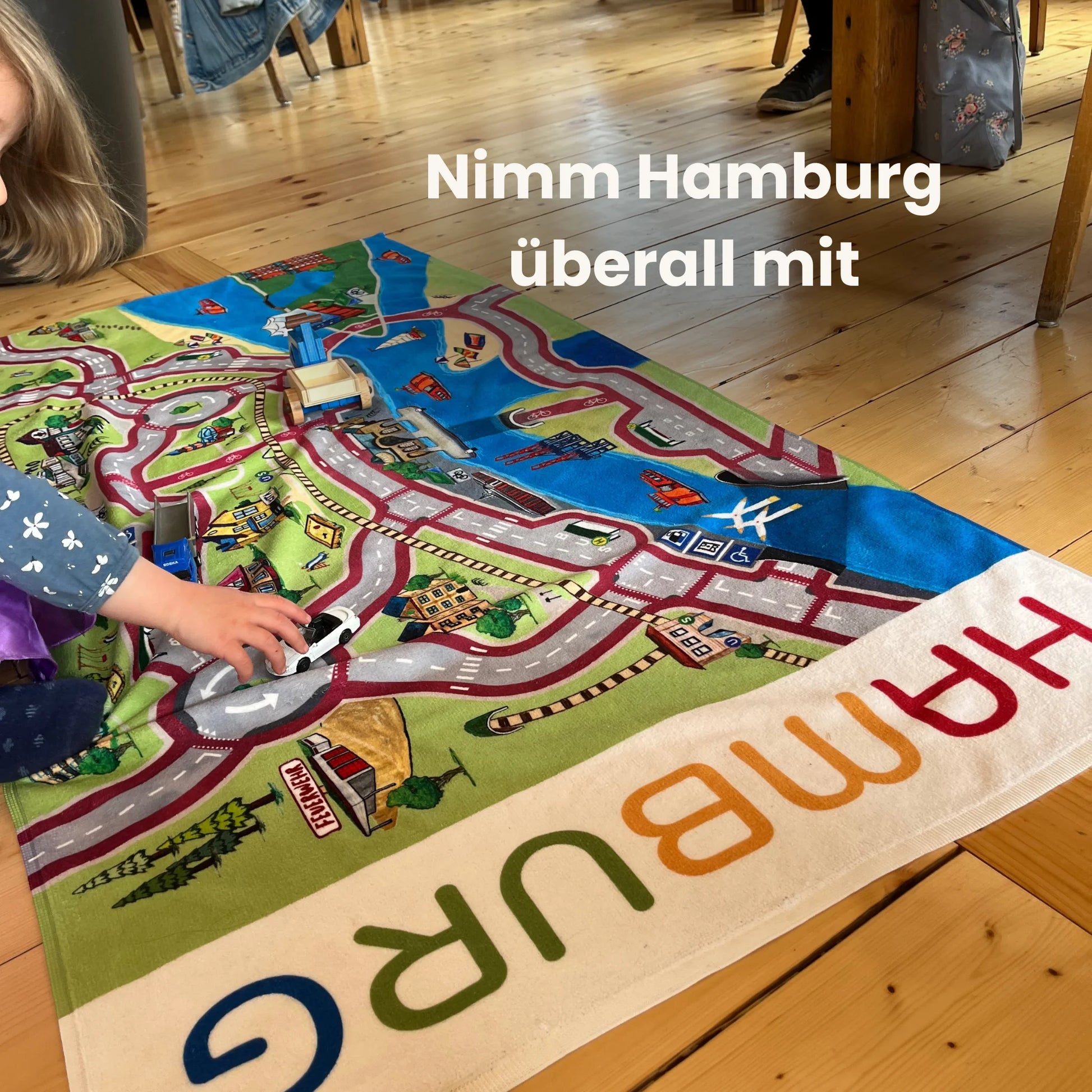 Child playing on a vibrant handtuch spielteppich featuring a colorful Hamburg city map design.