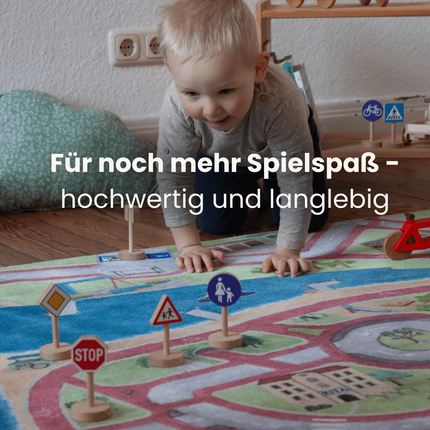 Kleinkind spielt auf Spielteppich mit Verkehrsschildern aus Holz für kreatives Lernen und Verkehrssicherheit.