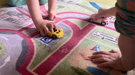 Auf dem Spielteppich Berlin von Spielwende parkt ein Kind ein gelbes Auto auf dem Parkplatz.