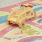 Spielzeug-Lastenrad von Spielwende mit Kinderaufsatz in natur steht auf dem Spielteppich mit Radwegen.